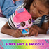 Gabby’s Dollhouse plush toy featuring pink soft fabric cube-shaped cat with embroidered brown eyes, small crown, and colorful outfit, held by a child on a bed in a cozy indoor bedroom setting.