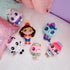 Gabby's Dollhouse plush toys in bright pastel fabrics, small rounded character shapes with embroidered faces, arranged on a quilted bed, showcasing collectible set and playful themed characters.