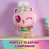 Gabby's Dollhouse Cakey Cat plush toy in pink and green fabric, rounded kitten shape with floral crown and wings, displayed on a table in a pastel room, emphasizing imaginative playtime companion.