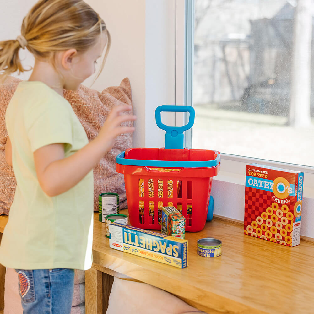 Girl playing with the Melissa and Doug Fill & Roll Grocery Basket Play Set