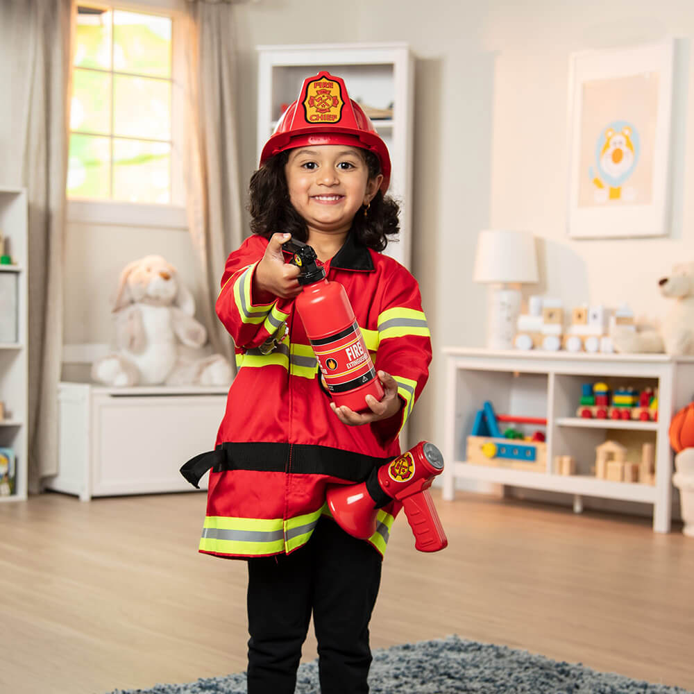 Grl playing with the fire extinguisher from the Melissa and Doug Fire Chief Role Play Costume Set