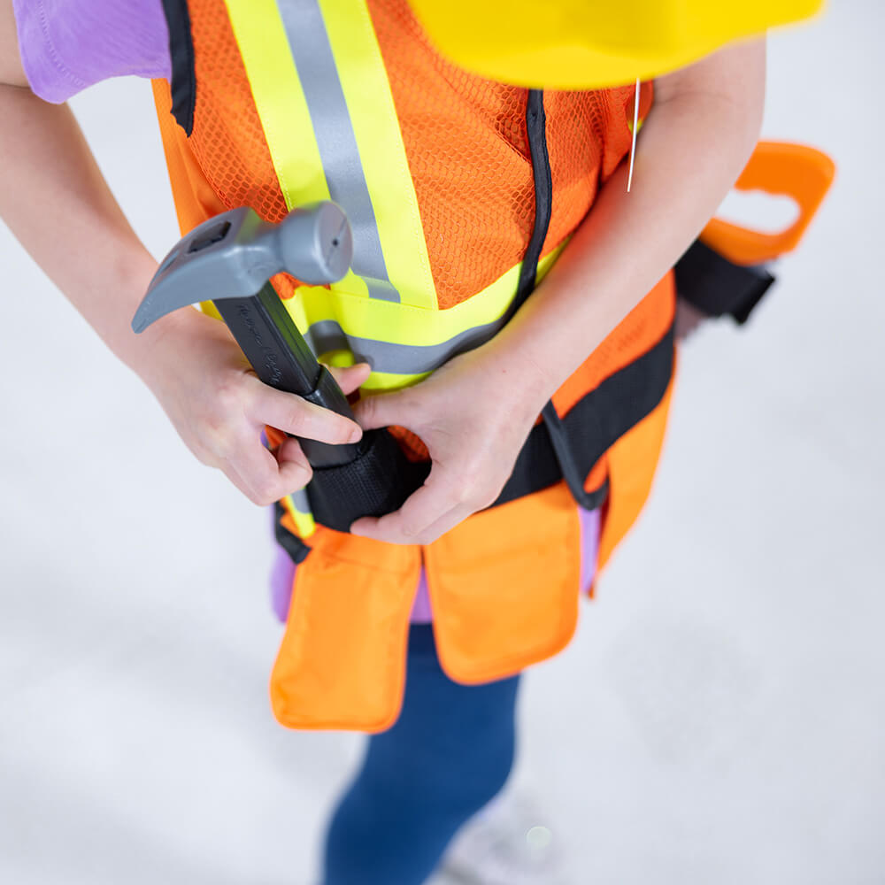 Child adjusting her hammer in the Melissa and Doug Construction Worker Role Play Costume Set