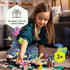 Smiling girl placing a pink fish figure on GraviTrax Junior Ocean tiles with playful marine decorations, promoted as the perfect gift for curious kids aged three and up.