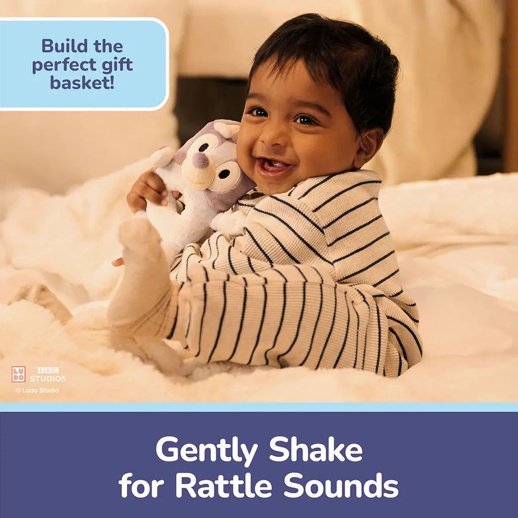 Bluey plush ring rattle features light blue plush fabric, rounded body, and built-in rattle sound, designed to respond to gentle shaking and encourage auditory exploration for infants.