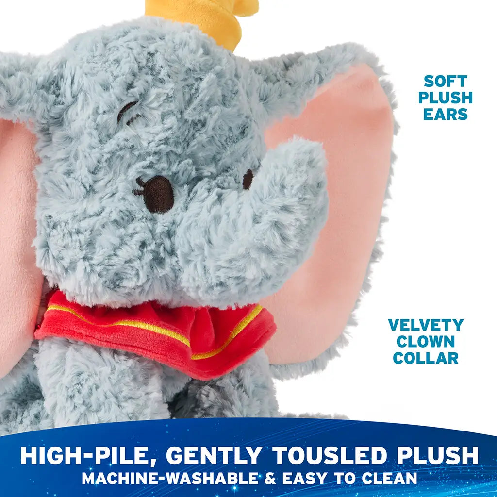 Disney Dumbo plush toy in soft blue with machine-washable high-pile plush, velvety pink ears, yellow hat, and red clown collar, designed for easy cleaning while maintaining a cuddly seated form for everyday play.