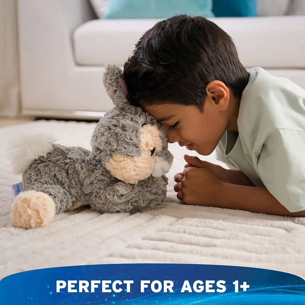 GUND Cozys Disney Thumper plush in gray and cream textured fabric, hugged by a smiling child indoors to illustrate emotional comfort, soft floppy limbs, and a toddler-friendly plush made for everyday cuddles.