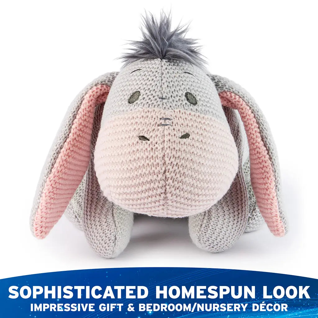 Disney Eeyore knit plush is shown from the front with gray and blush knit fabric, droopy ears, stitched eyes and nose, and a rounded seated shape designed for cuddling and decorative display.