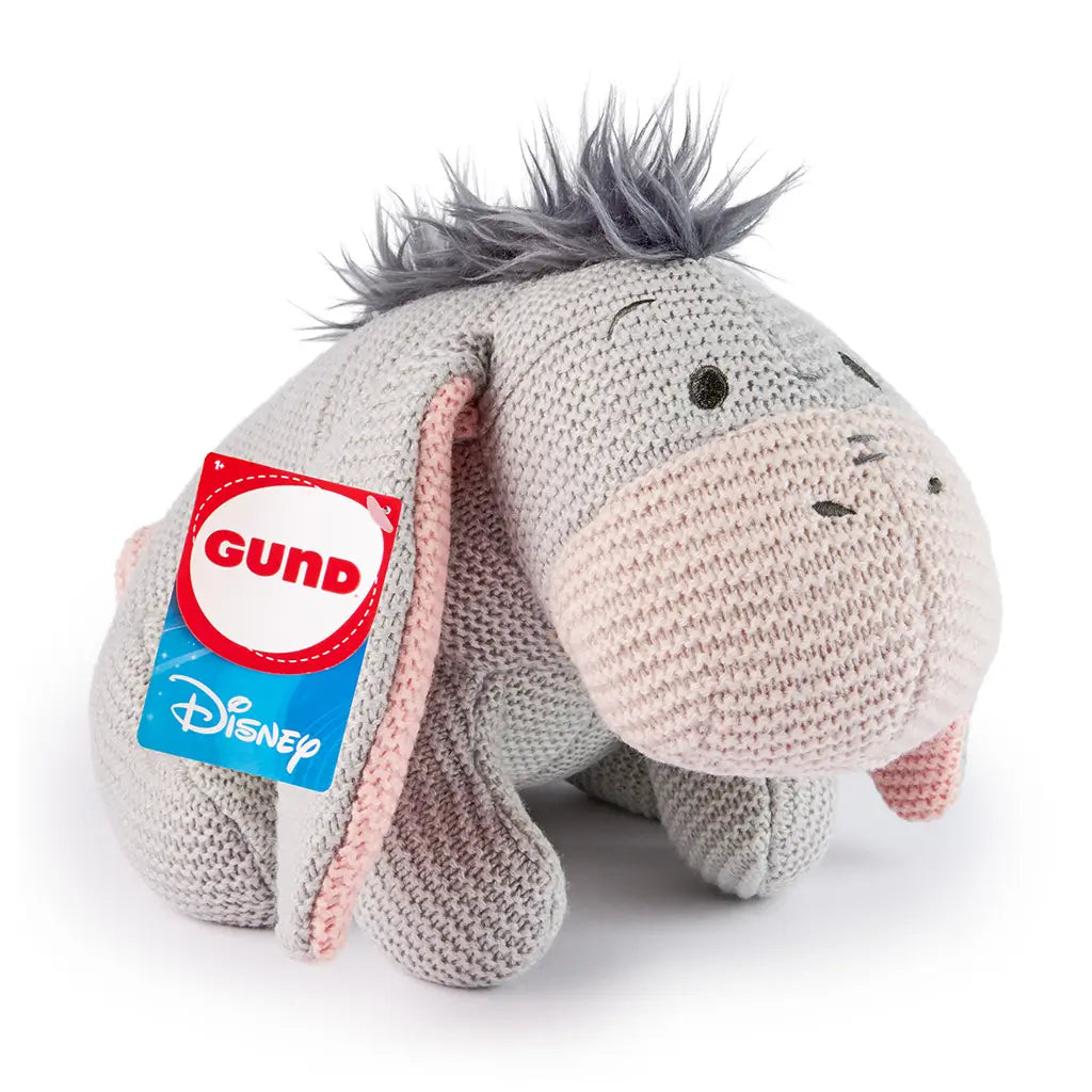 Disney Eeyore knit plush features soft gray chunky-knit fabric with pale pink accents, floppy ears, and a gentle rounded form, shown from a left angled view for cozy play or nursery display.
