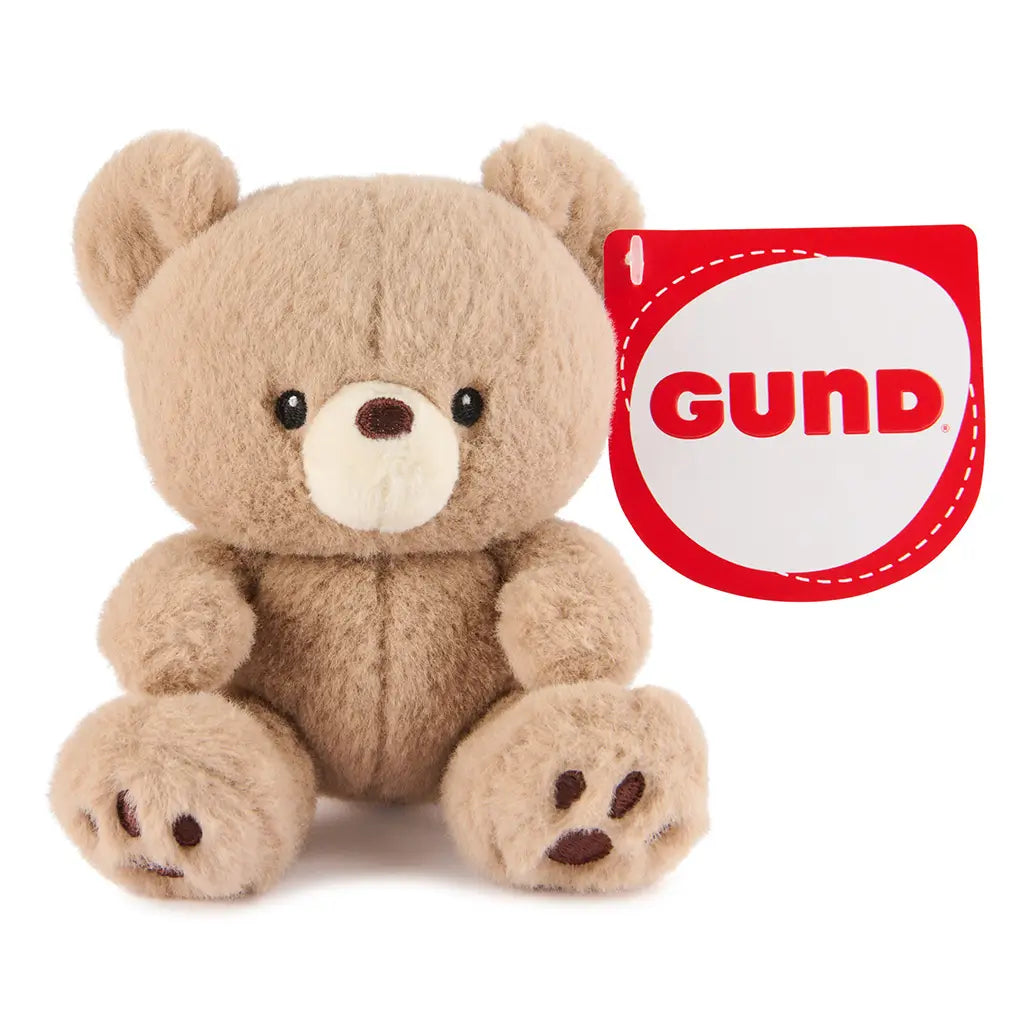 GUND Kai plush teddy bear in light beige soft fuzzy fabric with rounded shape and small limbs, compact stuffed toy with embroidered eyes and nose, seated on a clean white background