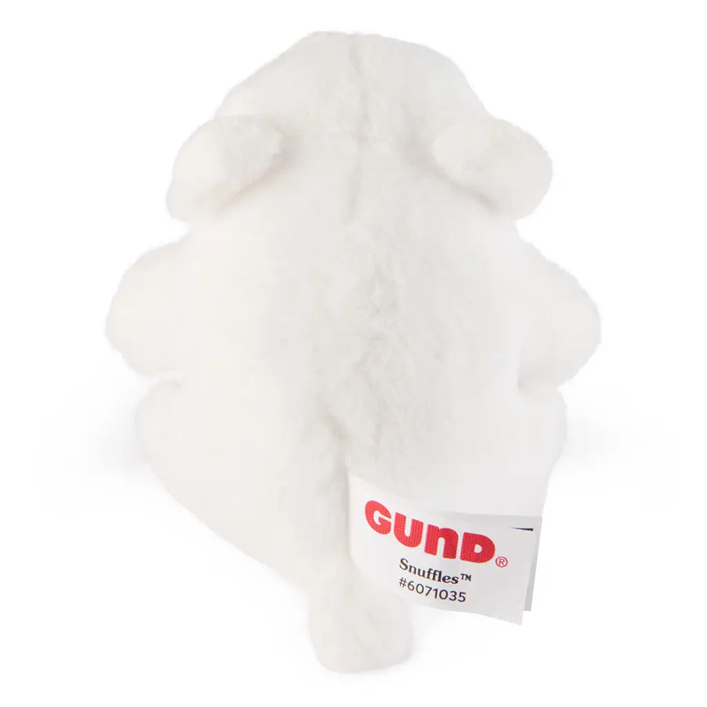 GUND Snuffles plush teddy bear in white soft fabric with rounded compact shape, rear view showing stitched seam and branded tag detail, small cuddly toy on a plain white background