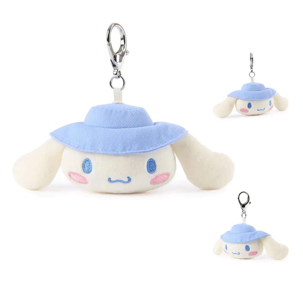 Cinnamoroll plush keychain by GUND in creamy white velour with floppy ears, rounded face shape, embroidered blue eyes and blush cheeks, blue camping hat, and silver clip, designed as a 3.5 inch collectible charm.