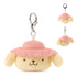 Pompompurin plush keychain from GUND in warm yellow velour fabric with smooth texture, rounded puppy face, embroidered eyes and smile, pink camping hat, and silver clip, designed as a portable 3.5 inch surprise plush.