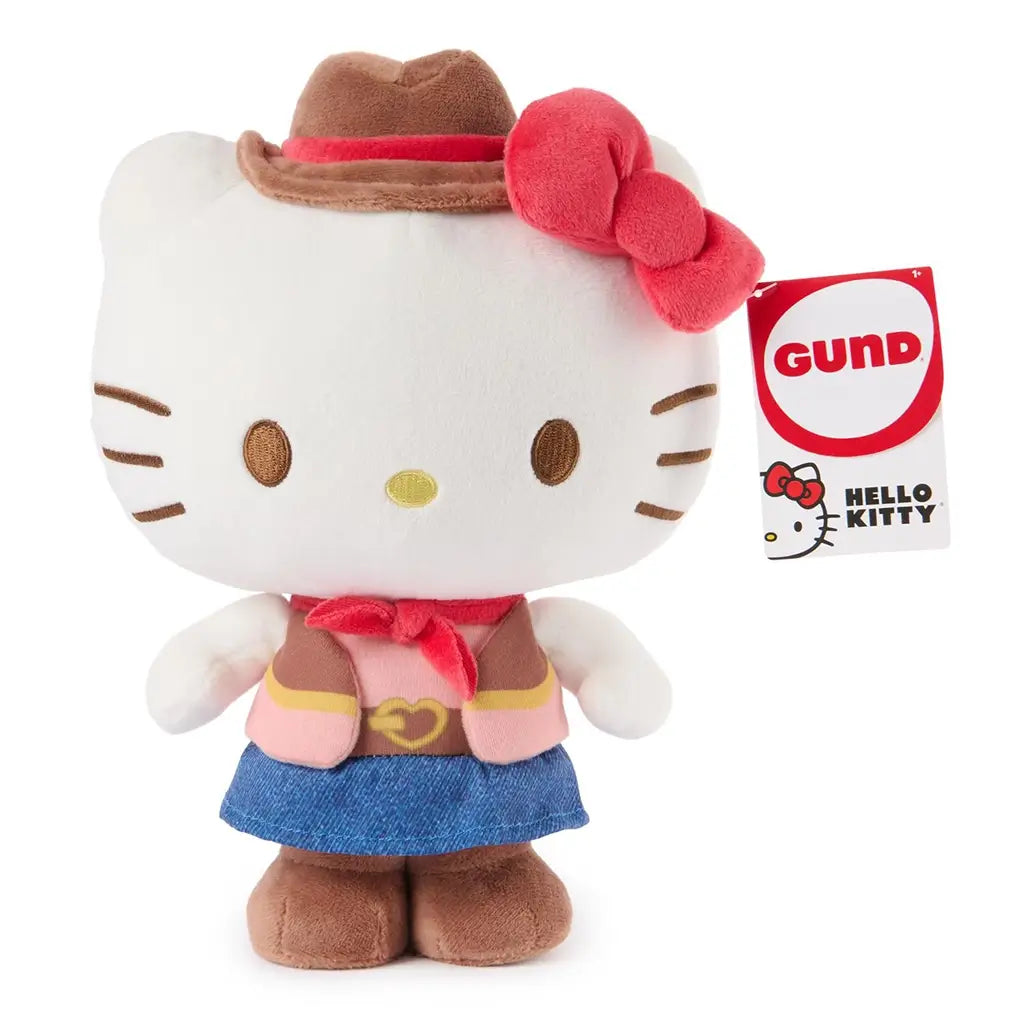 Hello Kitty cowgirl plush by GUND in white velour fabric with smooth soft texture, rounded character form, embroidered eyes and whiskers, wearing a brown felt cowboy hat, red bow, pink vest, blue skirt, and brown boots on a white background.