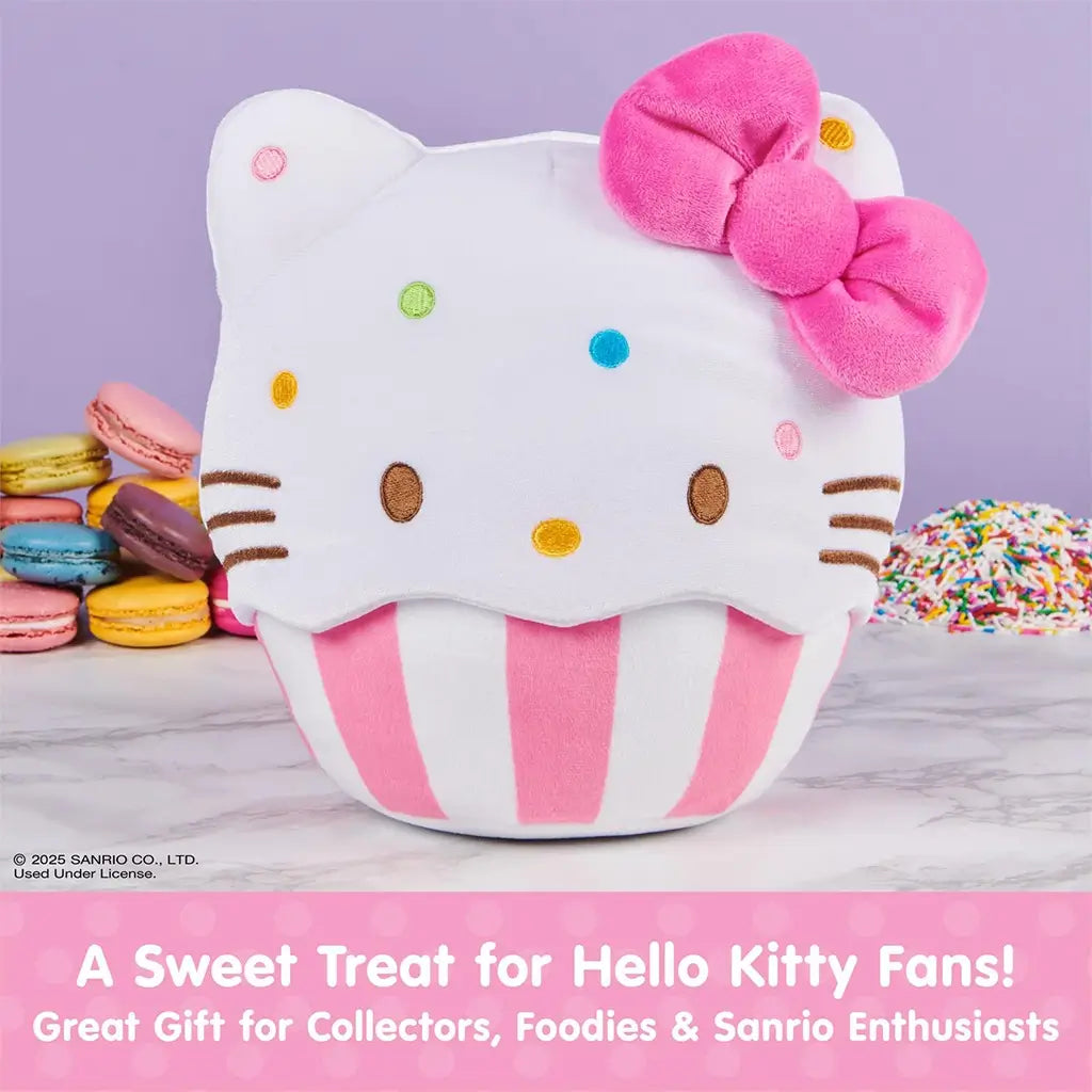 GUND Hello Kitty cupcake plush shown as a collectible Sanrio character in white velour fabric with smooth texture, rounded cupcake form, pink bow accent, striped baking cup base, and colorful embroidered sprinkles, displayed as part of a themed plush assortment.