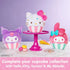 GUND Hello Kitty cupcake plush displayed with Kuromi and My Melody cupcake plush in soft velour fabric, rounded dessert shapes, pastel pink and purple colors, striped cupcake bases, and embroidered details, arranged on a cake stand and marble surface.