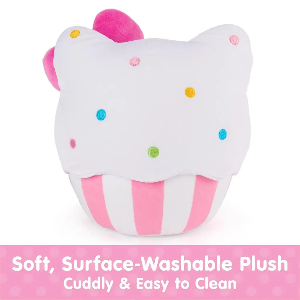 GUND Hello Kitty cupcake plush in white velour fabric with soft cuddly texture, rounded cupcake shape, pink striped baking cup, embroidered facial features and rainbow sprinkles, highlighting surface-washable construction on a clean white background.
