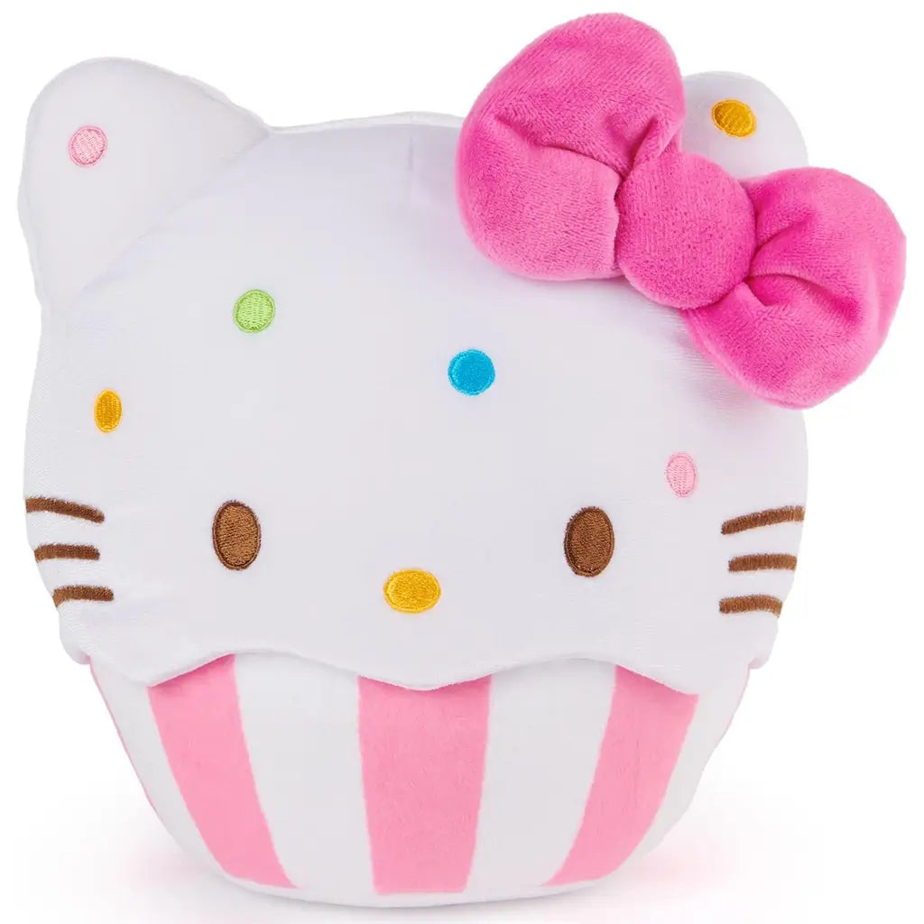 GUND Hello Kitty cupcake plush in white velour fabric with smooth soft texture, rounded cupcake character form, embroidered eyes and whiskers, colorful sprinkle details, pink bow, and striped baking cup base on a white studio background.