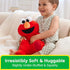GUND Sesame Street Elmo plush made of ultra-soft red jersey cotton with floppy arms and quilted accents, gently under-stuffed for a squishy feel, designed for hugging while a smiling toddler relaxes on a couch at home.