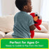 GUND Sesame Street Elmo plush toy in bright red plush fabric with floppy arms and embroidered smile, designed for hugging, carried by a young child in a casual living room setting during imaginative play.