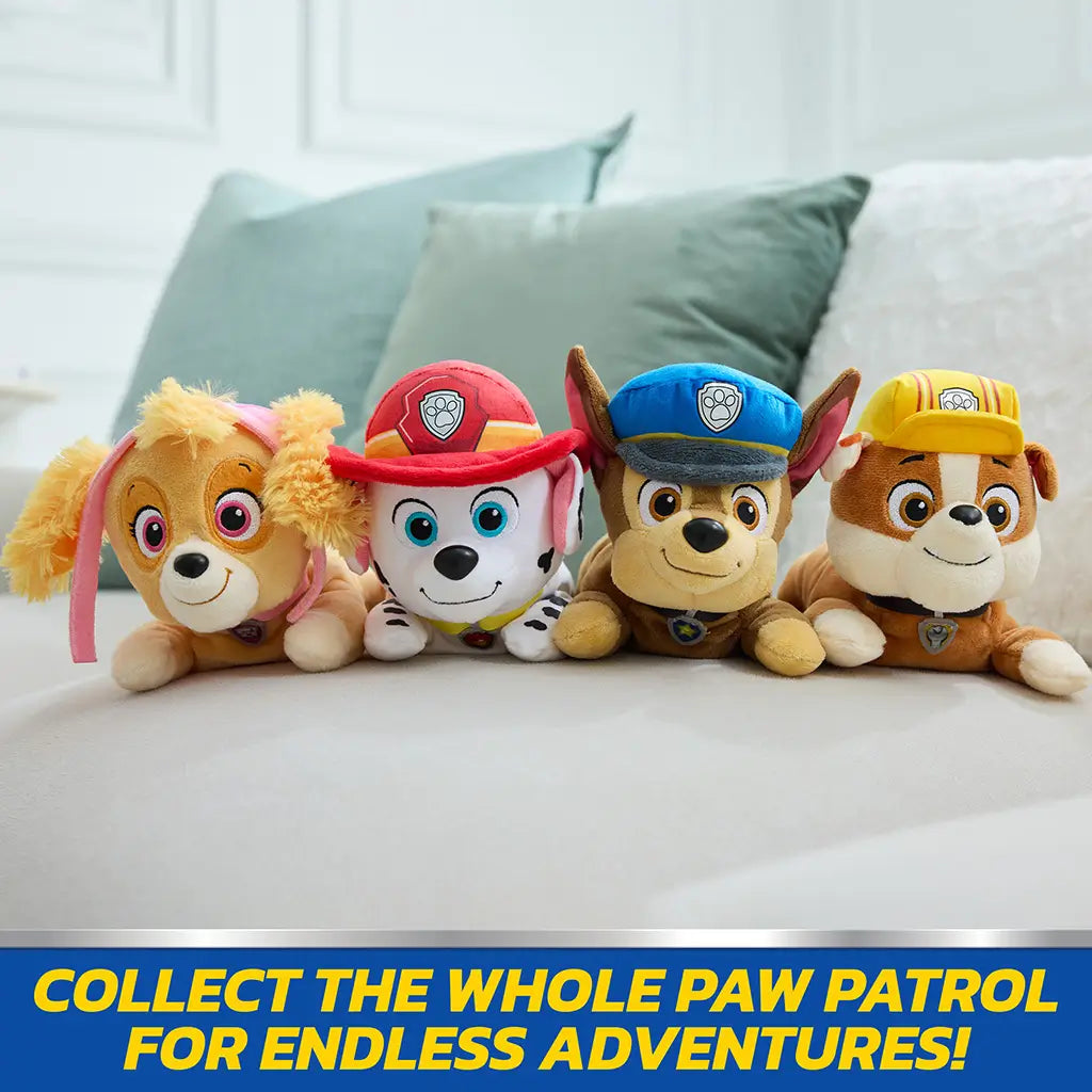 Paw Patrol plush set featuring Skye, Marshall, Chase, and Rubble in bright multicolor soft fabric, small rounded dog figures arranged in a row on couch in a cozy living room
