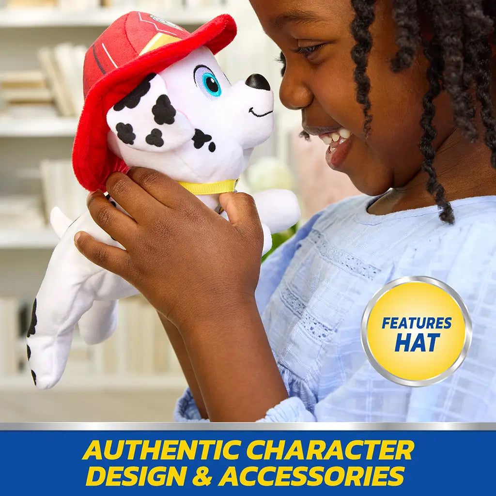 Paw Patrol Marshall plush toy in white and black spotted soft fabric with red firefighter hat and collar, rounded Dalmatian dog form designed for imaginative play held by child indoors