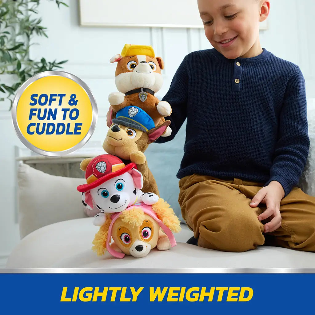 Paw Patrol plush toys stacked vertically in colorful soft fabric including Skye, Marshall, Chase, and Rubble, lightweight rounded dog shapes balanced by child on indoor couch