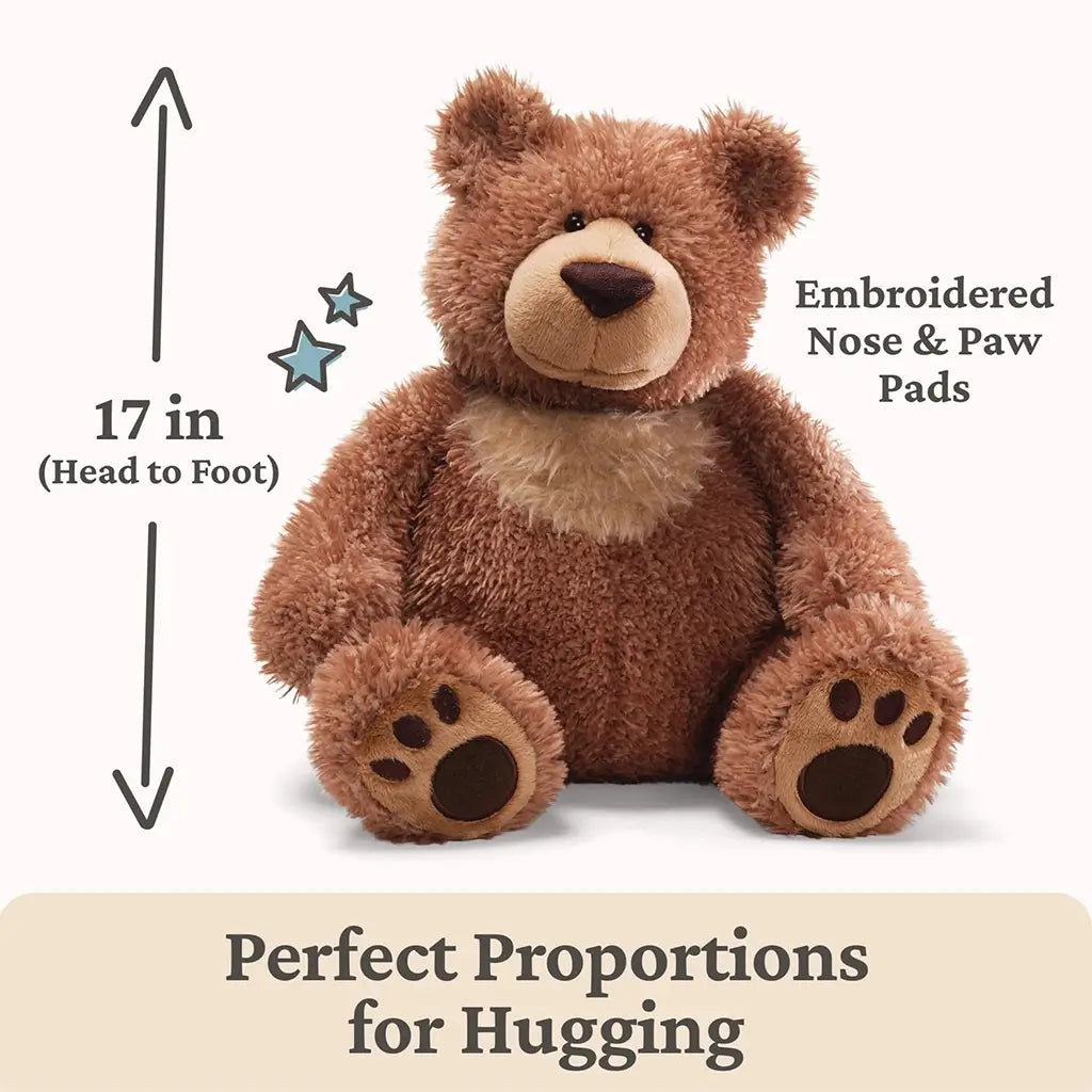 GUND Slumbers teddy bear plush in warm brown fuzzy fabric with rounded seated bear form, embroidered nose and paw pads, shown with a 17 inch head to foot measurement graphic highlighting perfect hugging proportions.