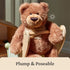 GUND Slumbers teddy bear plush in medium brown fuzzy fabric with plump poseable body, rounded seated bear form, embroidered nose and paw pads, displayed sitting on a wooden toy chair in a softly lit indoor setting.