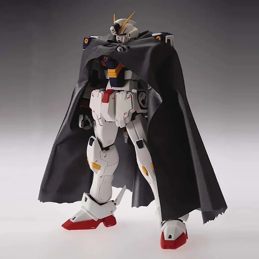 Gundam figure white plastic armored humanoid robot with black cape and skull motif chest, Crossbone Gundam X1 Ver Ka posed standing with draped fabric accessory on smooth gray gradient studio background