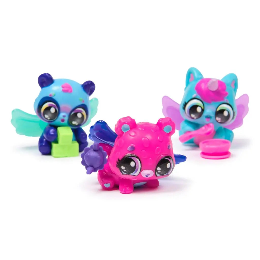 Neon Rainbow Hatchimals characters in bright pink, teal, blue, and purple with glossy textures, large expressive eyes, wings, and small accessories, arranged on a clean white background.