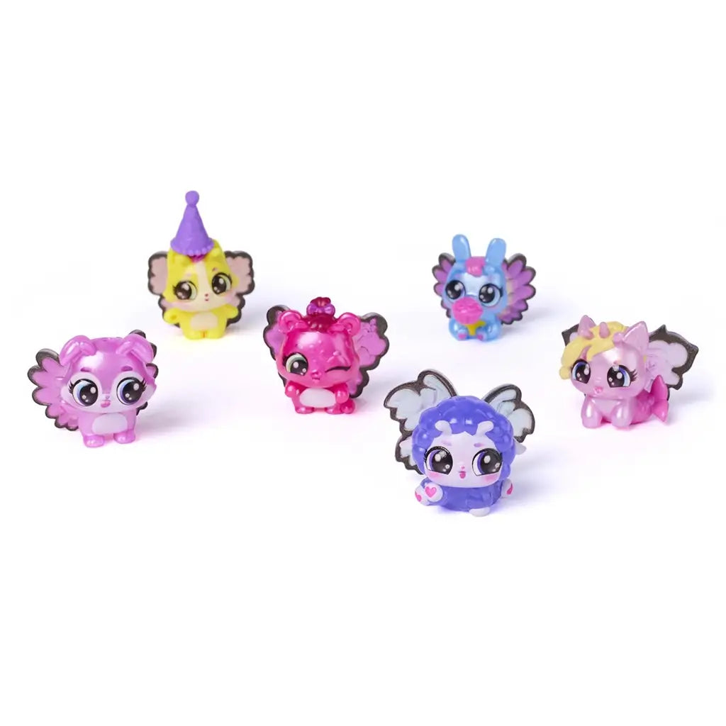 Hatchimals Bloomables collectible characters lineup featuring small pastel animal figures with shiny plastic texture, oversized expressive eyes, decorative wings, and floral hats, displayed evenly on a white backdrop.