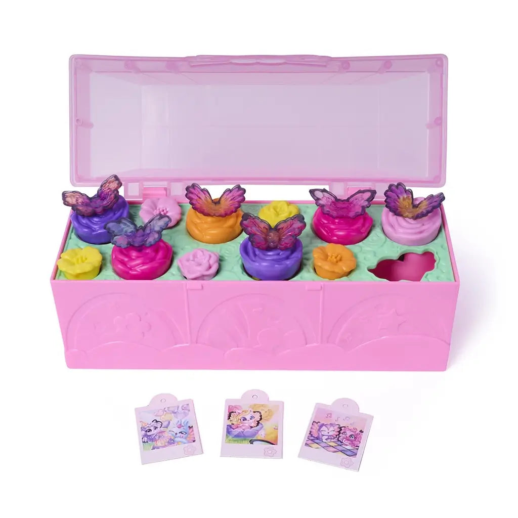 Hatchimals Bloomables Bloom Bash playset opened to reveal pink plastic base, pastel flower decorations, collectible mini figures, and interactive elements arranged to create a whimsical garden party display.