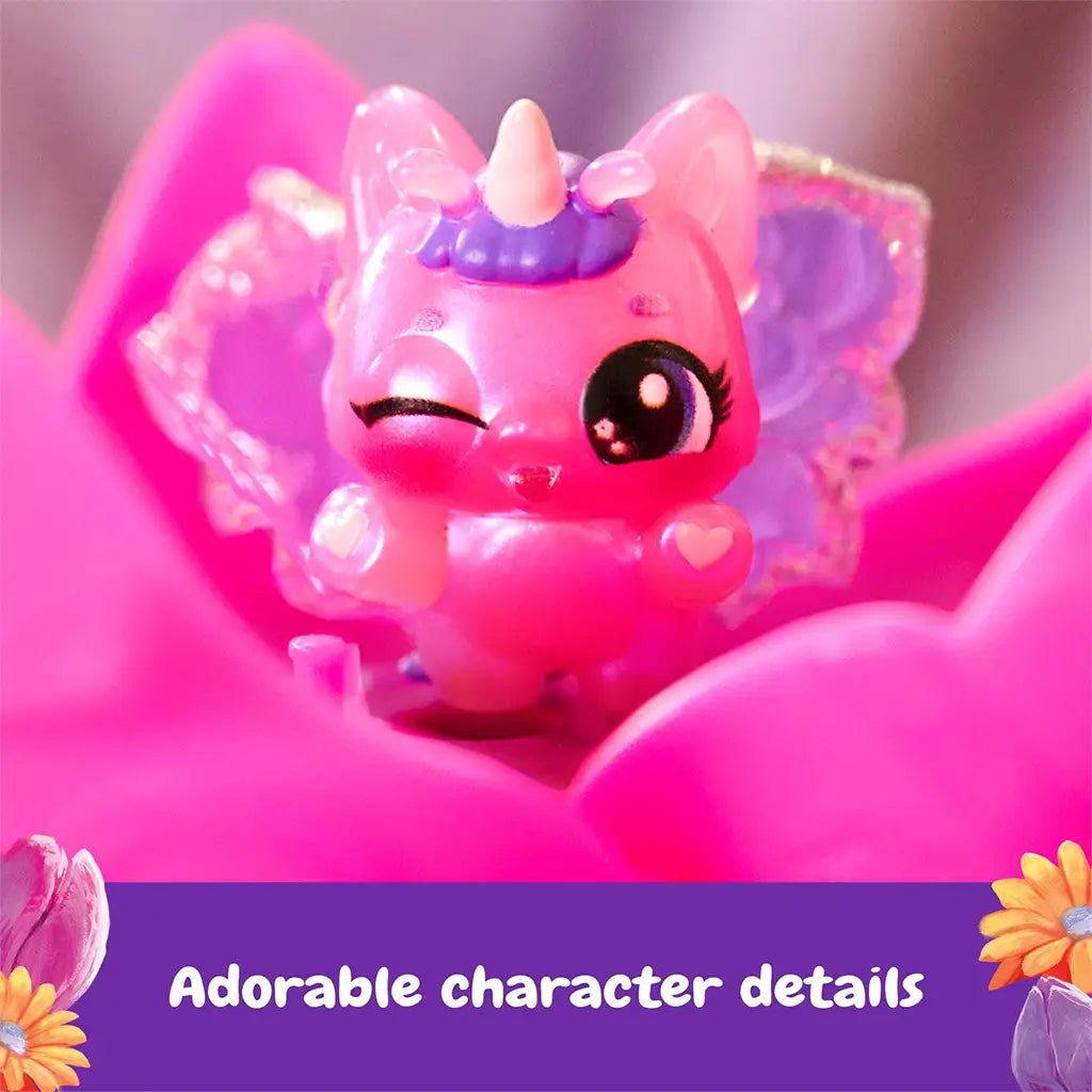 Hatchimals Bloomables Flower Fest character close-up featuring glossy pink mini figure with winking eye, tiny horn, translucent wings, and heart details, seated inside a bright pink flower petal.