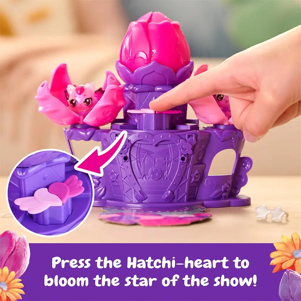 Hatchimals Bloomables Flower Fest flower reveal action showing purple stage with large pink blossom opening upward to reveal a tiny character, highlighting interactive bloom mechanism and storytelling play feature.