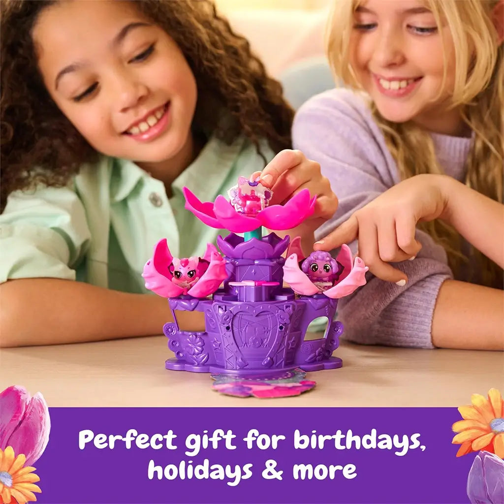 Hatchimals Bloomables Flower Fest playset shown in use by two smiling children, featuring purple stage, pink flowers, and collectible characters, illustrating gift-ready toy appeal for birthdays and holidays.