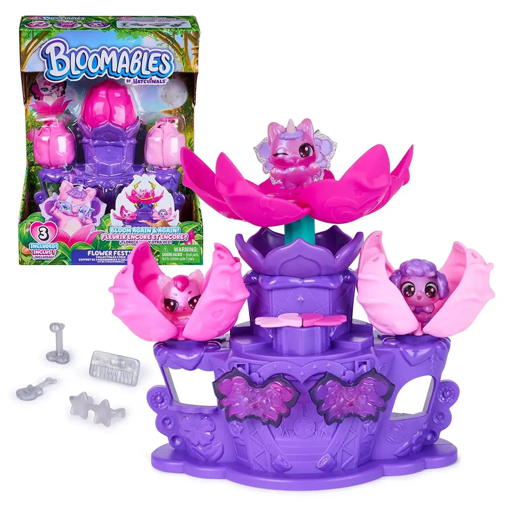 Hatchimals Bloomables Flower Fest playset package showing colorful printed box with clear plastic window, purple stage base, pink flower pods, and three exclusive mini characters arranged for imaginative blooming play.