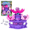 Hatchimals Bloomables Flower Fest playset package showing colorful printed box with clear plastic window, purple stage base, pink flower pods, and three exclusive mini characters arranged for imaginative blooming play.