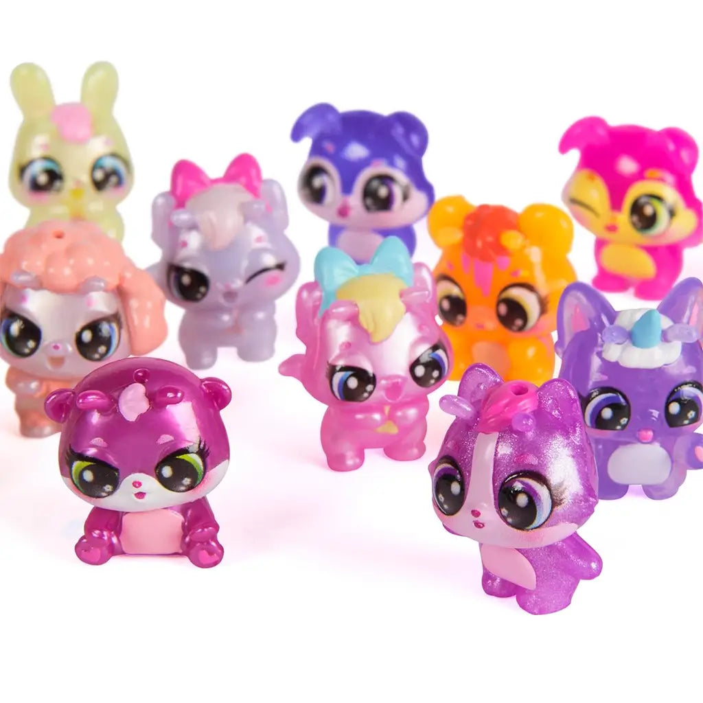 Hatchimals Bloomables collectible characters assortment displayed together, featuring multiple pastel animal figures in pink, purple, orange, blue, and glitter finishes with oversized eyes and rounded toy proportions.