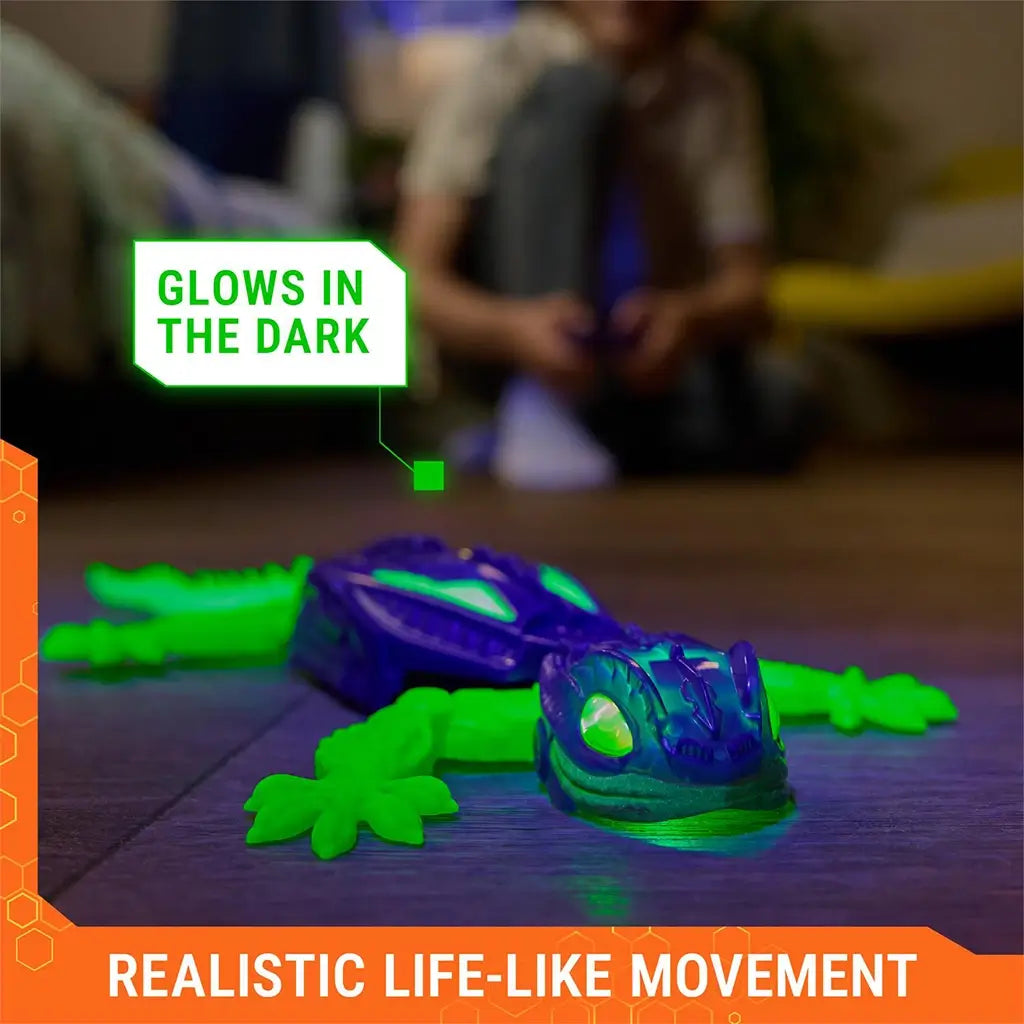 HEX BOTS Wall Crawler gecko in purple plastic with bright green glow in the dark legs and tail, stretched across a floor surface in dim lighting to highlight realistic movement.