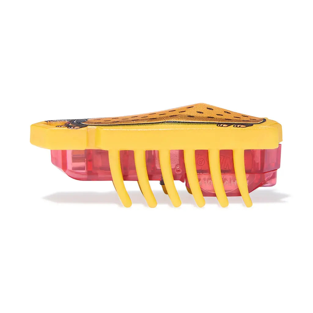 HEXBUG Nano robot bug side view in yellow plastic with translucent red base, low rectangular body and evenly spaced rubber legs, designed for quick vibrating motion on a clean white background.