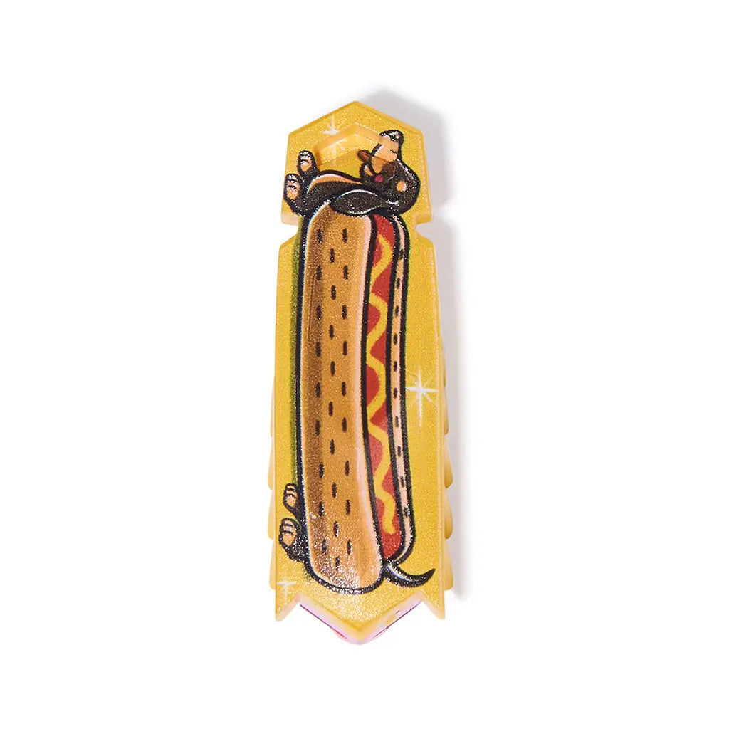 HEXBUG Nano hotdog robot bug in yellow glossy plastic with cartoon dachshund and bun graphic, slim rectangular body with angled tip, designed as a vibrating micro robot toy on a plain white background.