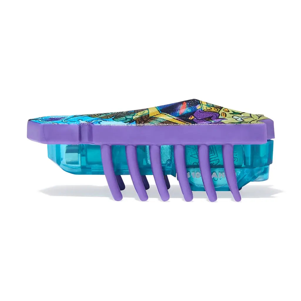 HEXBUG Nano toy robot bright blue and purple plastic shell with scuba diver graphic and teal translucent base in side profile, showing low crawling insect-like form with multiple flexible legs on white background