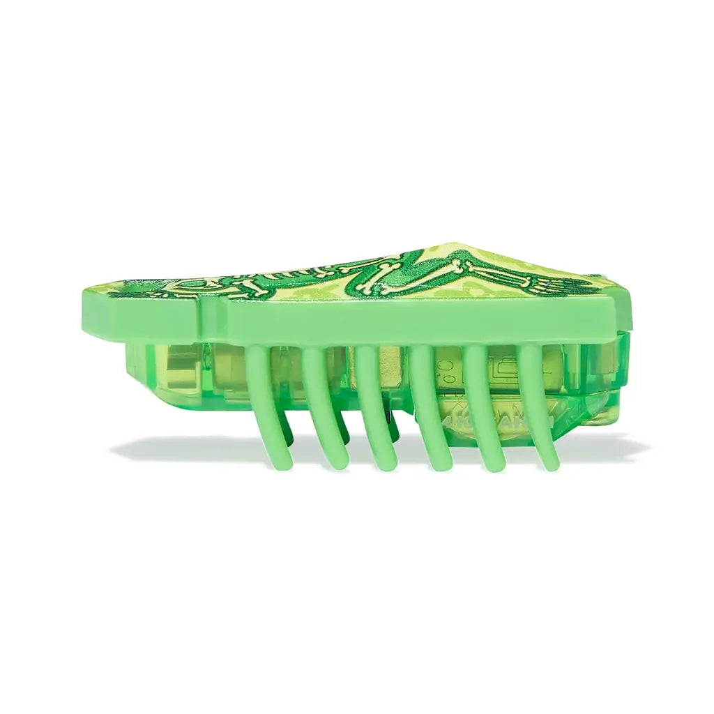 HEXBUG Nano toy robot bright green plastic shell with skeleton frog design and translucent base in side profile, showing low crawling insect-like form with evenly spaced flexible legs on a white background