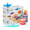 Hey Clay ocean craft kit with bright modeling clay tubs and smooth tools beside a colorful box showing rounded sea creatures on a sandy ocean scene, presented in a clean studio setting.