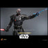 Hot Toys Darth Malgus figure in black textured armor extends one arm with blue Force lightning while holding a red lightsaber, posed against a smooth gray background.