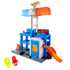 Hot Wheels City Downtown Police Tower playset viewed from the right, blue and gray plastic tower with orange launch ramp, rotating rooftop arms, police emblem door, and accessories for stunt play.