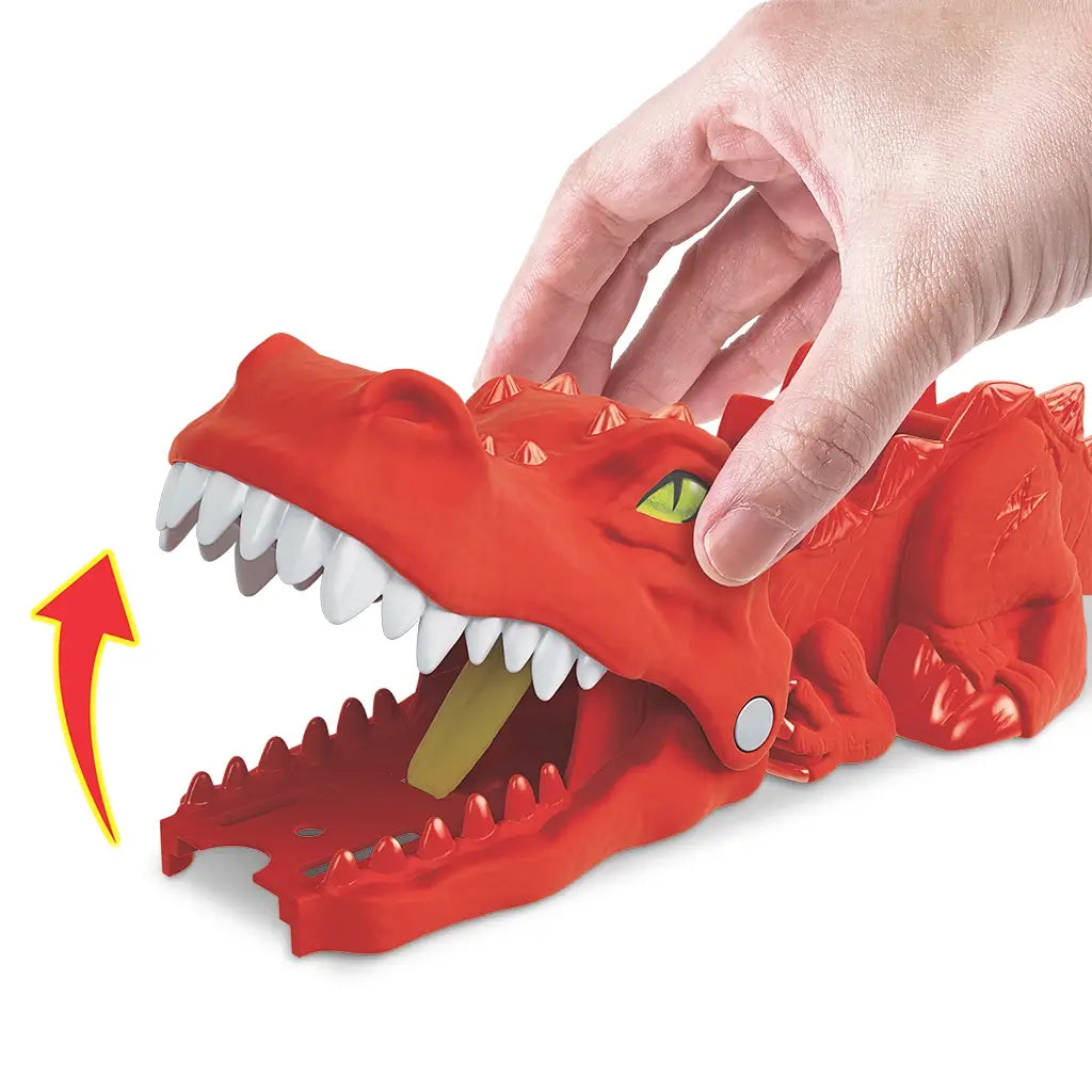 Close-up of Hot Wheels City Nemesis Dino Launcher showing a red dinosaur head with white teeth as a hand lifts its jaw, highlighting chomping action for toy cars during play.