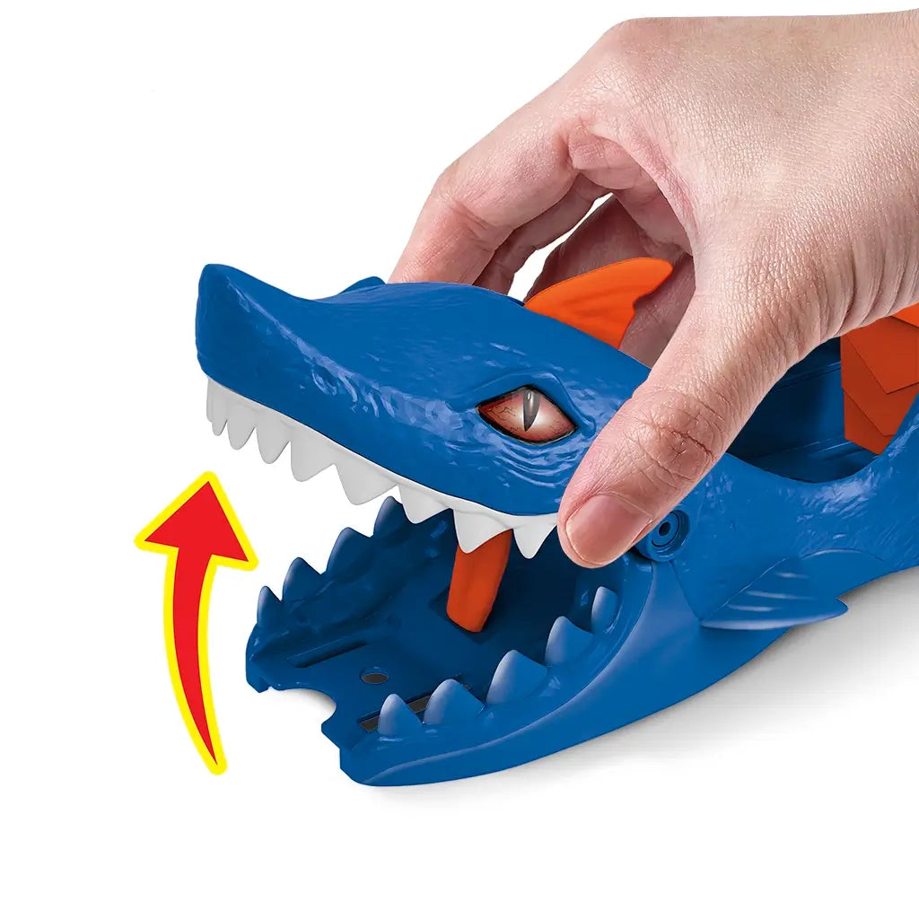 Close-up of Hot Wheels City Nemesis Shark Launcher toy with a hand lifting the blue shark’s jaws, showing interactive chomping action and orange lever inside mouth.