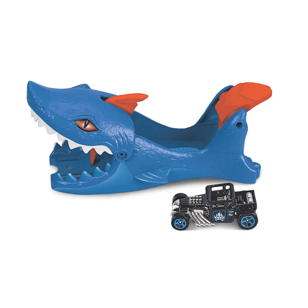 Side view of Hot Wheels City Nemesis Shark Launcher featuring blue shark body with orange fins and teeth, alongside a black die-cast car with chrome engine detailing.