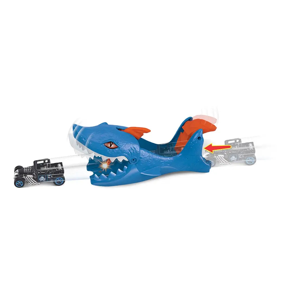 Hot Wheels City Nemesis Shark Launcher playset featuring a blue shark with orange fins and wide jaws, launching a black die-cast car through its mouth for high-speed stunts.